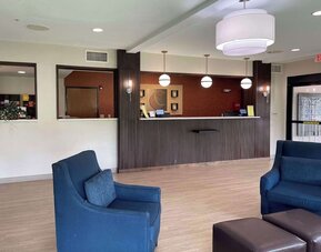 Reception area with front desk, pendant lighting, lounge chairs, and modern décor at Comfort Suites San Antonio SeaWorld - Lackland AFB.