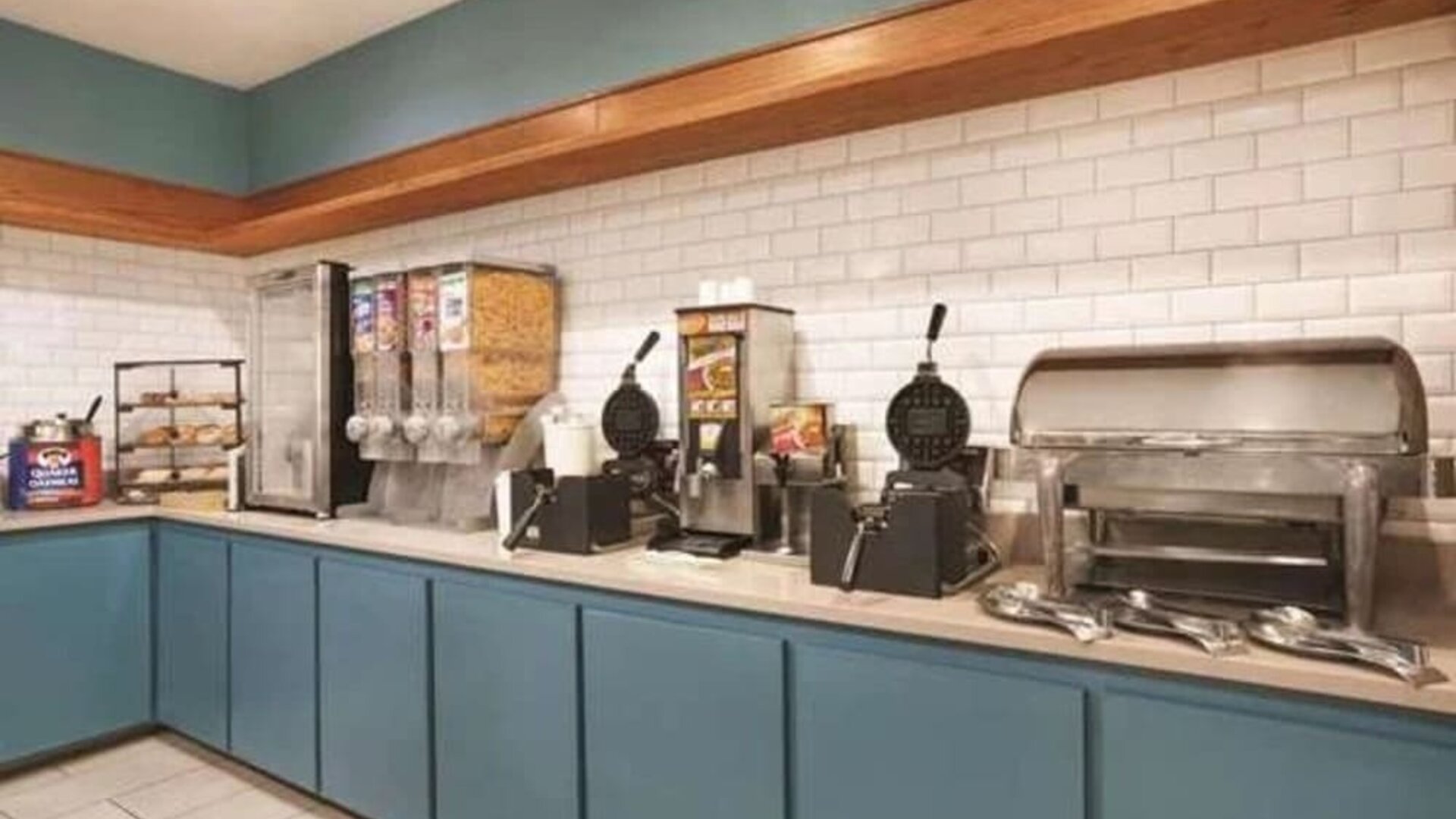 Breakfast station with waffle makers, cereal dispensers, pastries, and hot-food service area at SureStay by Best Western Lewisville Dallas.