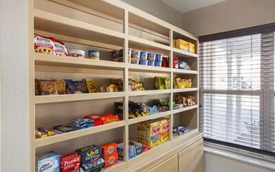 Hotel convenience area with shelves stocked with snacks, drinks, and travel essentials at SureStay by Best Western Lewisville Dallas.