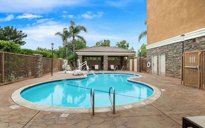 Outdoor swimming pool with lounge area and covered seating at Best Western Ontario Mills Mall.