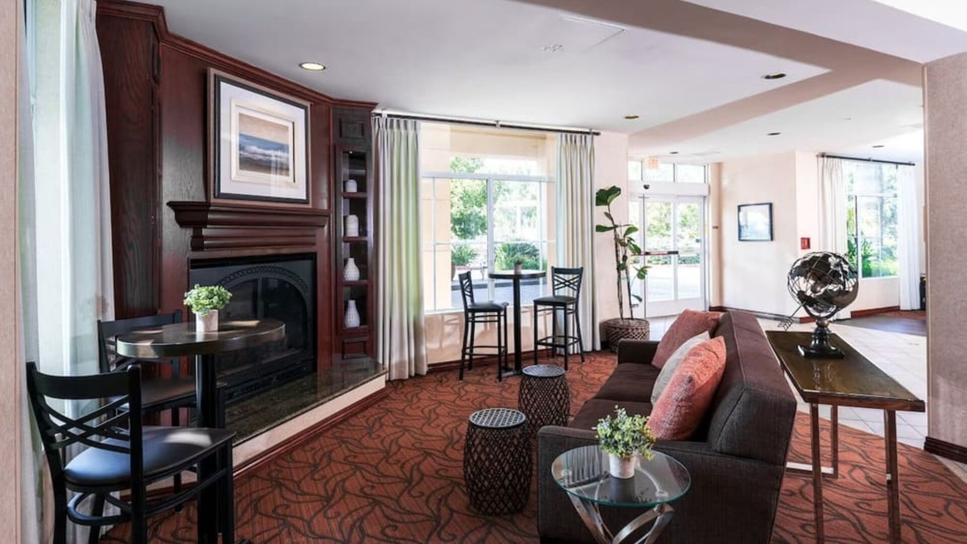 Lobby lounge with fireplace, sofa seating, high-top tables, and decorative furnishings at Best Western Ontario Mills Mall.
