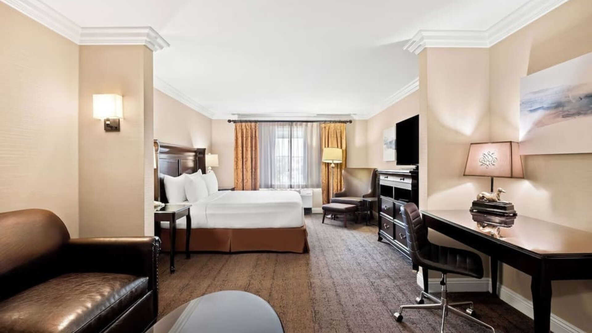 Spacious king guest room with sofa, work desk, television, and seating area at Best Western Ontario Mills Mall.