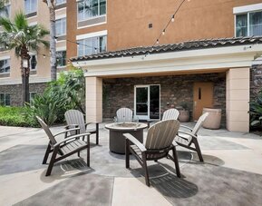 Outdoor terrace with chairs arranged around a fire pit at Best Western Ontario Mills Mall.