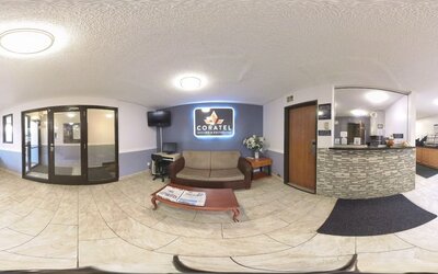 Reception and lobby area with front desk, sofa seating, coffee table, television, and business workstation at Coratel Inn & Suites By Jasper Hastings.