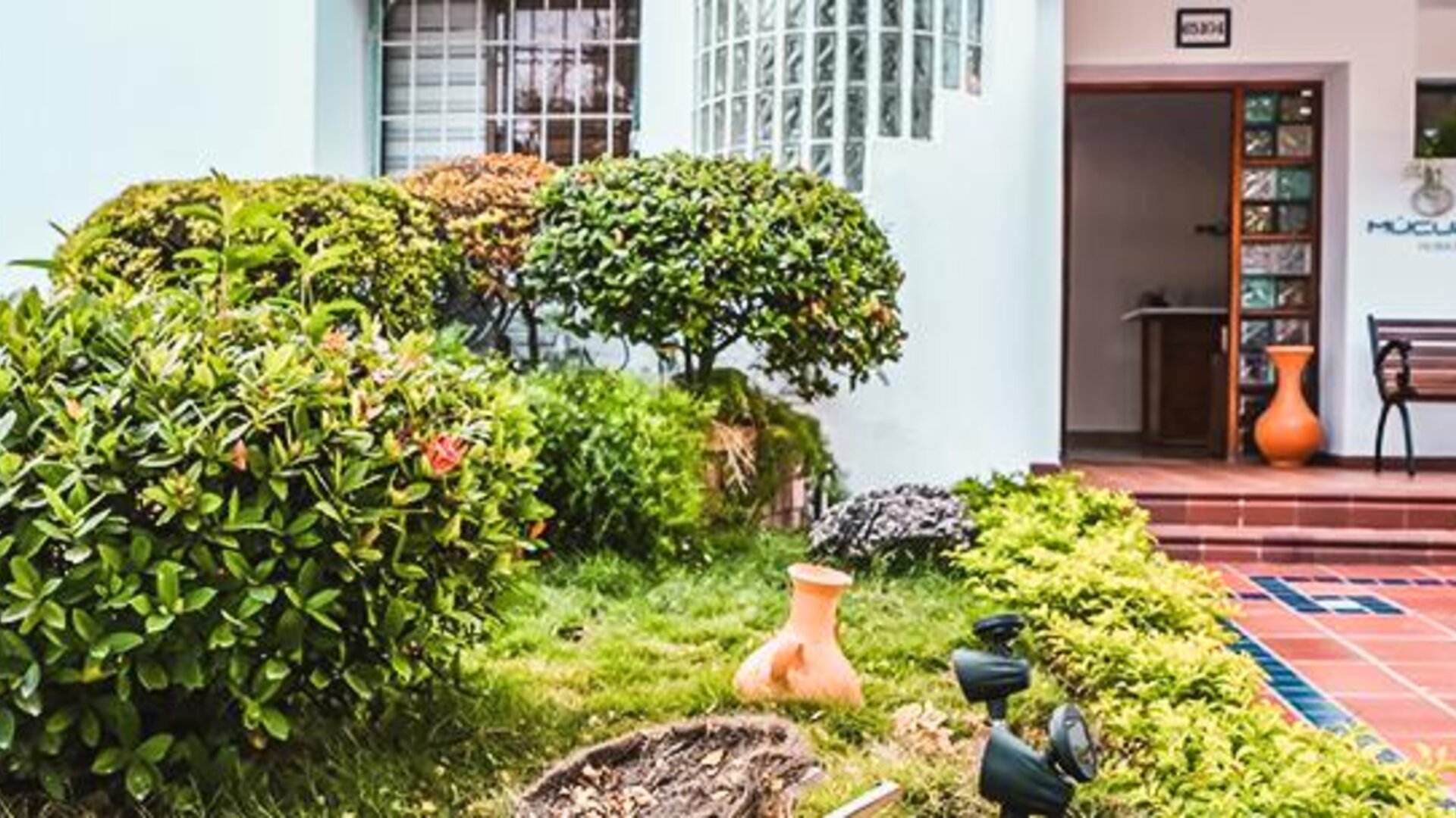 Exterior entrance and landscaped garden with tropical greenery and seating at Múcura Hotel & Spa.