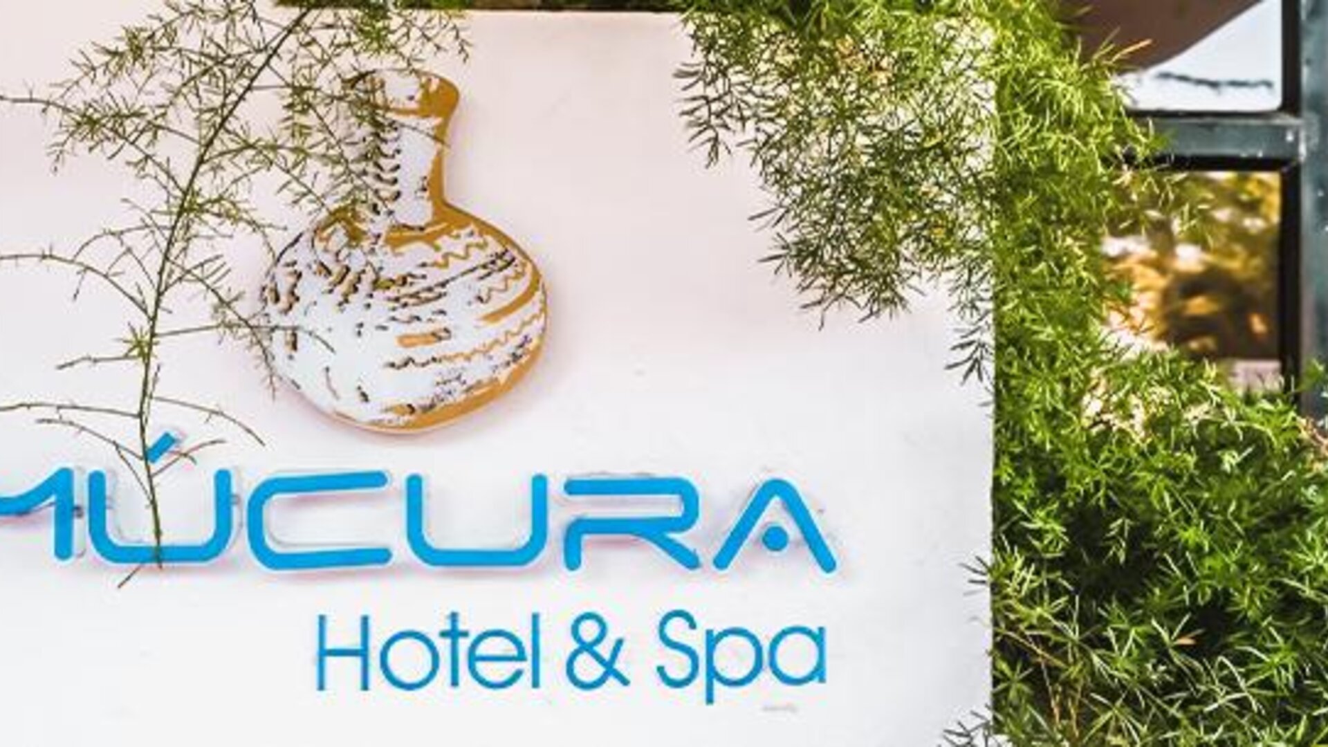 Exterior hotel signage surrounded by greenery at Múcura Hotel & Spa.