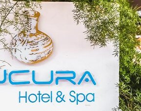 Exterior hotel signage surrounded by greenery at Múcura Hotel & Spa.