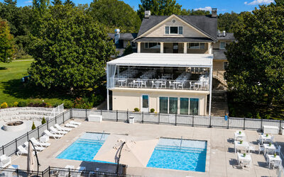 Outdoor pool area featuring multiple swimming pools, sun loungers, terrace seating, and the main resort building at SKYLARANNA Resort & Spa.