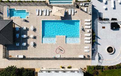 Aerial view of the outdoor pool complex featuring multiple pools, sun loungers, and surrounding deck area at SKYLARANNA Resort & Spa.
