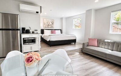 Spacious guest accommodation featuring a bed, sofa, dining area, refrigerator, kitchenette, and contemporary furnishings at SKYLARANNA Resort & Spa.