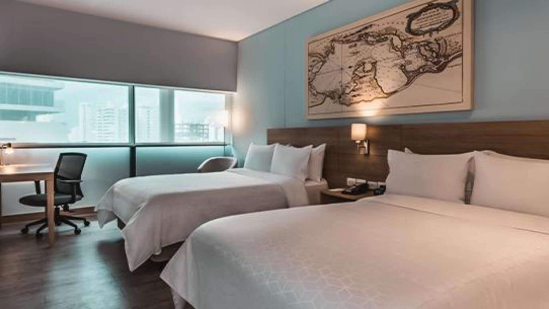 Modern guest room featuring two beds, a dedicated workspace, television, and large windows at Holiday Inn Express Cartagena Manga.