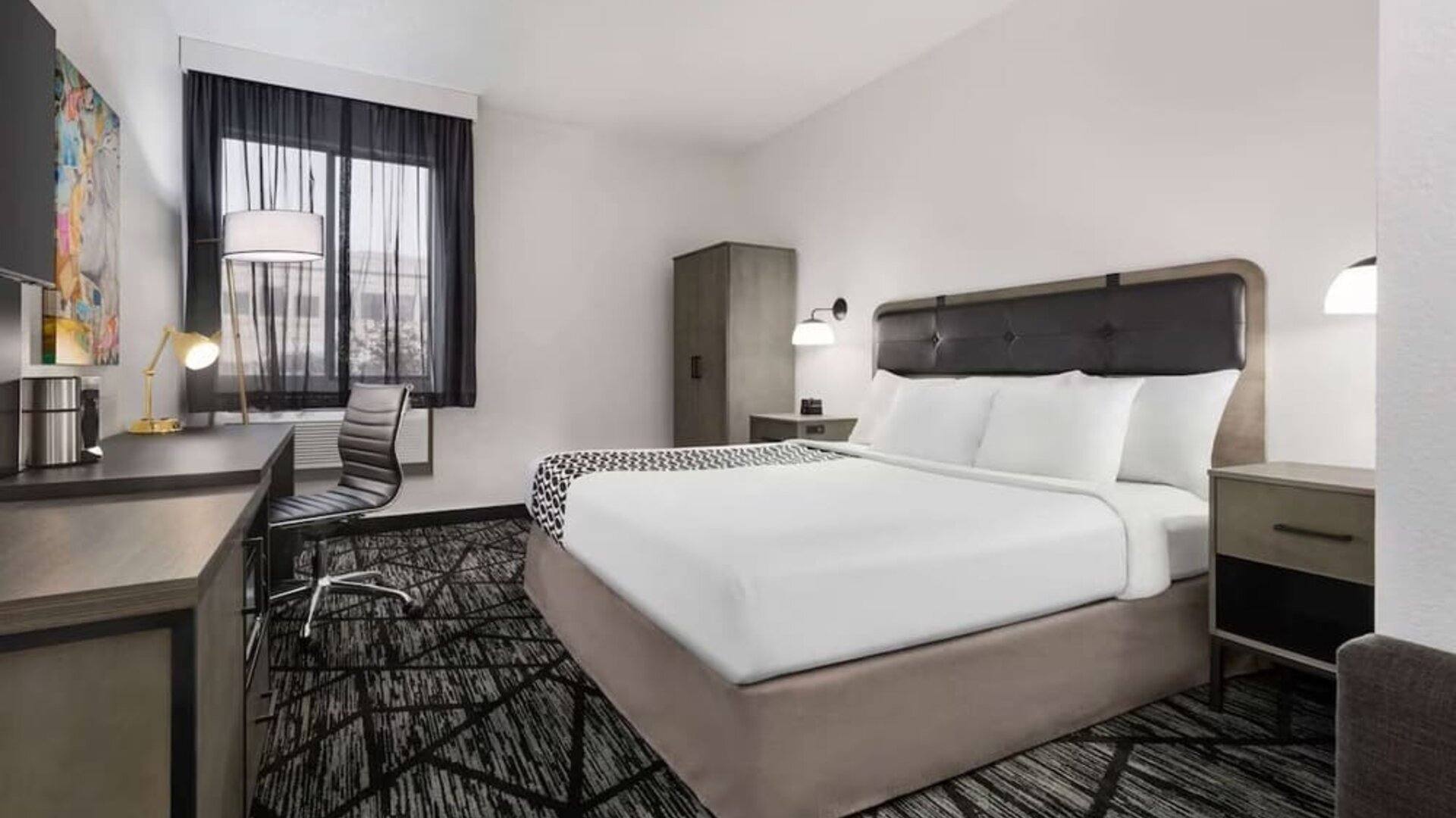 Comfortable guest room featuring a king bed, dedicated work desk, television, wardrobe, and contemporary décor at La Quinta Inn & Suites By Wyndham Cleveland Airport West.