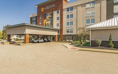 Exterior view of La Quinta Inn & Suites By Wyndham Cleveland Airport West featuring the hotel entrance, covered drop-off area, and landscaped surroundings.