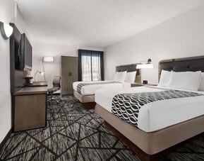 Comfortable guest room featuring two beds, a work desk, television, wardrobe, and modern furnishings at La Quinta Inn & Suites By Wyndham Cleveland Airport West.