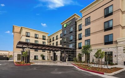 Exterior view of Holiday Inn & Suites Silicon Valley - Milpitas featuring the modern hotel building and covered entrance.