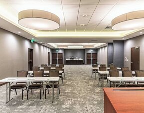 Spacious meeting facility featuring classroom-style tables and chairs, presentation space, and modern lighting at Holiday Inn & Suites Silicon Valley - Milpitas.