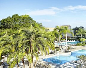 Large  outdoor pool surrounded by trees. 
