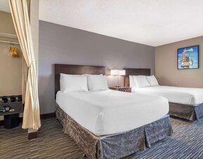 Guest room featuring two beds, bedside lighting, an in-room safe, and open wardrobe area. Best Western McCarran Inn.