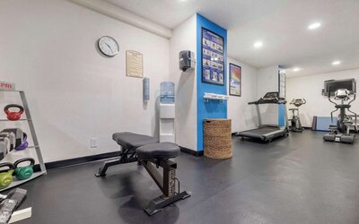 Fitness centre featuring a treadmill, exercise bike, elliptical machine, weight bench, and kettlebells. Best Western McCarran Inn.