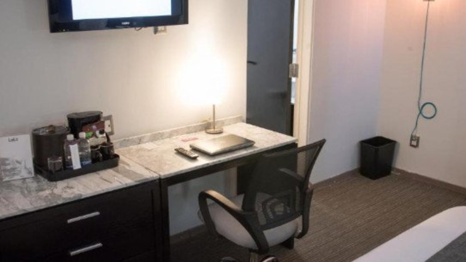 In-room workspace featuring a marble-top desk, ergonomic chair, coffee station and flat-screen TV. LaiLa Hotel CDMX.