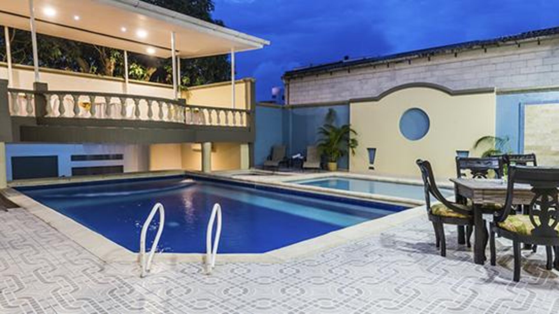 Outdoor swimming pool with patio dining area and covered terrace at Hotel Puerta de Oro.