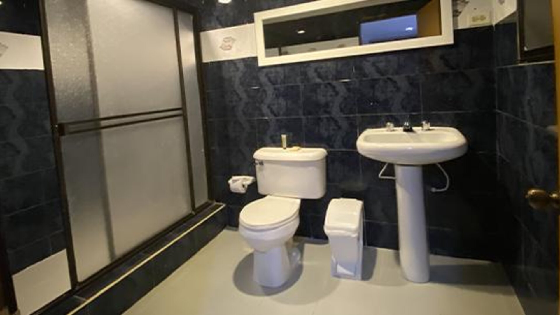 Accessible hotel bathroom with bathtub, shower seat, grab bars and toiletries at Hotel Puerta de Oro.