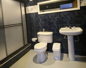 Accessible hotel bathroom with bathtub, shower seat, grab bars and toiletries at Hotel Puerta de Oro.