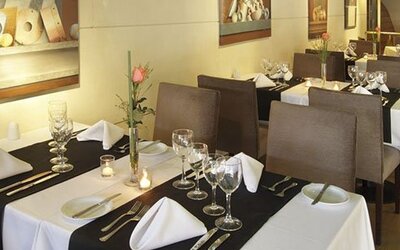 Dining room with white tablecloths, place settings, wine glasses, and floral centerpieces at El Conquistador Hotel.