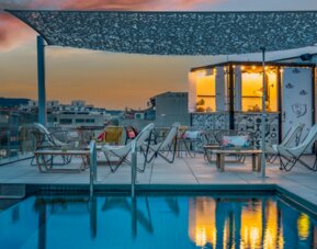 Rooftop pool with lounge chairs, outdoor seating, and a poolside bar area under a canopy at Hotel ibis Styles Barcelona City Bogatell.