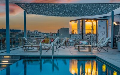 Rooftop pool with lounge chairs, outdoor seating, and a poolside bar area under a canopy at Hotel ibis Styles Barcelona City Bogatell.