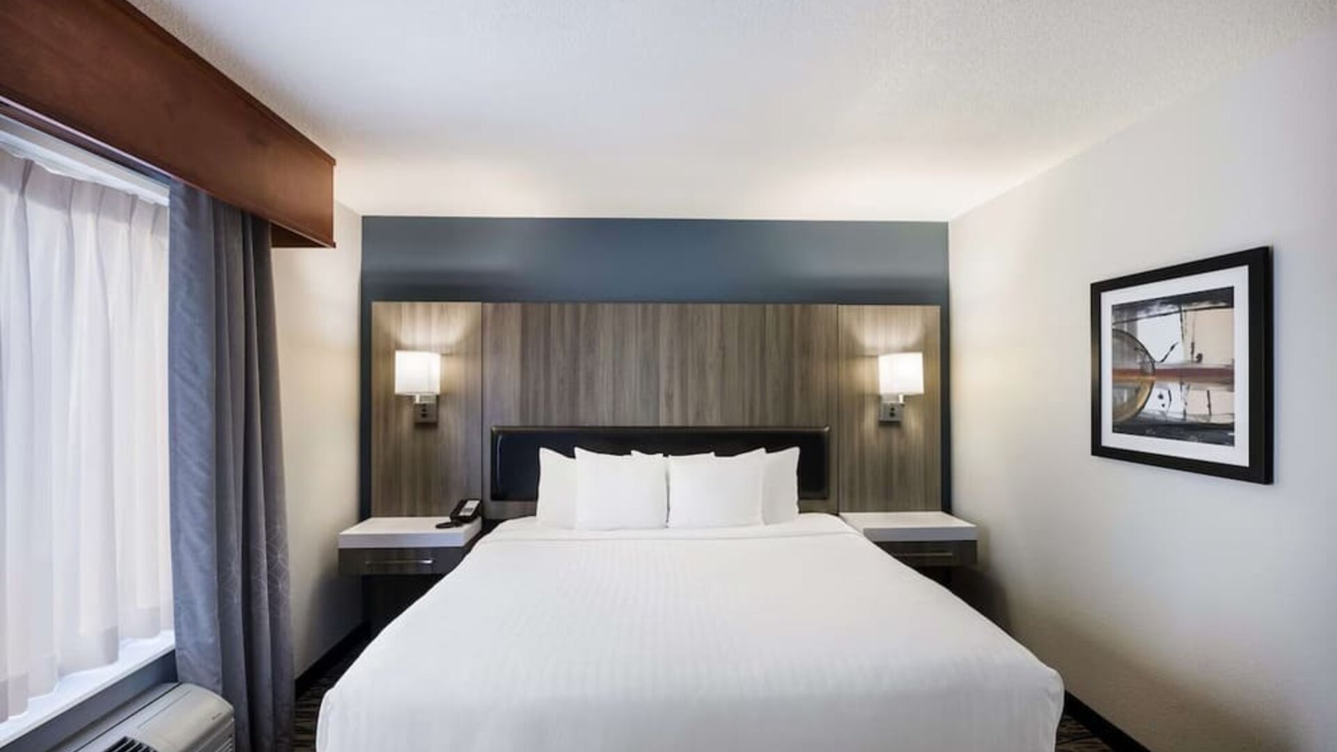 King guest room with large bed, bedside lighting, desk, and window at Best Western Plus Mountain View Auburn Inn.