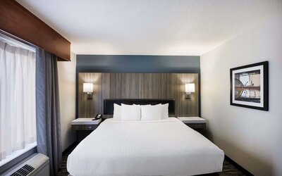 King guest room with large bed, bedside lighting, desk, and window at Best Western Plus Mountain View Auburn Inn.