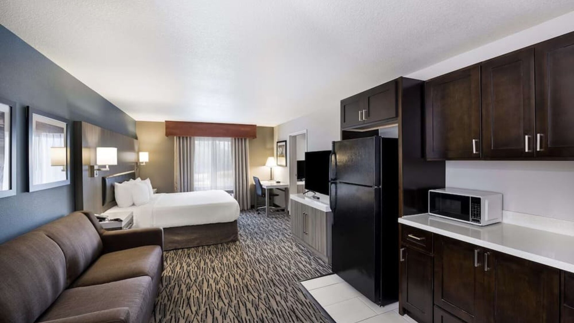 Spacious suite with a king bed, sofa, kitchenette, refrigerator, microwave, and desk at Best Western Plus Mountain View Auburn Inn.