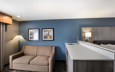 Suite seating area with a sofa, counter, sink, and lamp at Best Western Plus Mountain View Auburn Inn.
