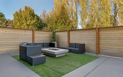 Outdoor patio with wicker seating, artificial turf, and a square fire pit at Best Western Plus Mountain View Auburn Inn.