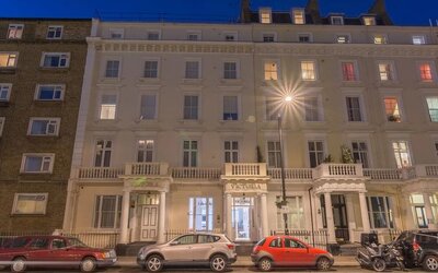 Exterior of Victoria Inn, a white multi-story Victorian-style building with decorative columns and balconies, photographed at night.
