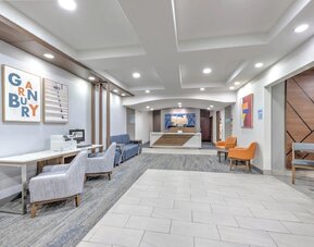 Hotel lobby and reception area with modern seating, colorful artwork, wood accents, and a front desk at Holiday Inn Express & Suites Granbury.
