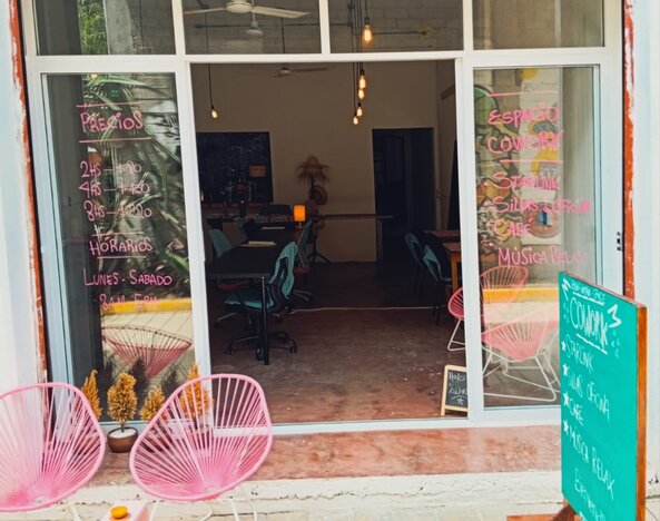 Entrance of the CoWork Zipolite cafe' with pink acapulco chairs at the entrance and a door to make the space more comfortable and sound-proof.