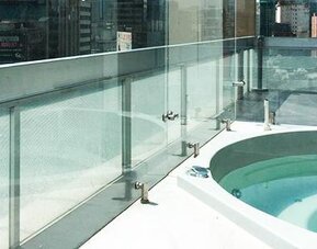 Outdoor whirlpool bath on a rooftop terrace with glass safety railings and city views at Hotel Block Suites.