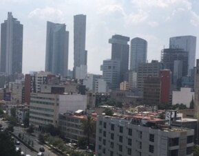 Daytime cityscape featuring high-rise office buildings, commercial streets and distant skyline views at Hotel Block Suites.
