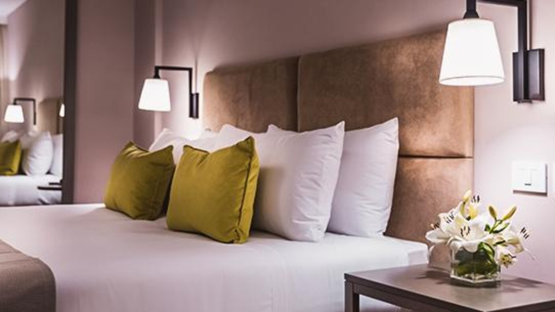 1. Guest room with a king-size bed, white bedding, olive-green accent cushions, upholstered headboard and bedside lighting at Howard Johnson Plaza Buenos Aires.