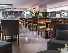 Dining area with tables, upholstered chairs, pendant lighting and polished floors at Howard Johnson Plaza Buenos Aires.
