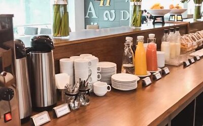 Breakfast coffee station with coffee machines, cups, saucers, juice bottles and pastries at Howard Johnson Plaza Buenos Aires.