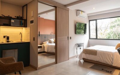 Studio-style guest room with a double bed, kitchenette, mirrored sliding wardrobe, air conditioning, and large windows at Hotel Living 35 Suites.