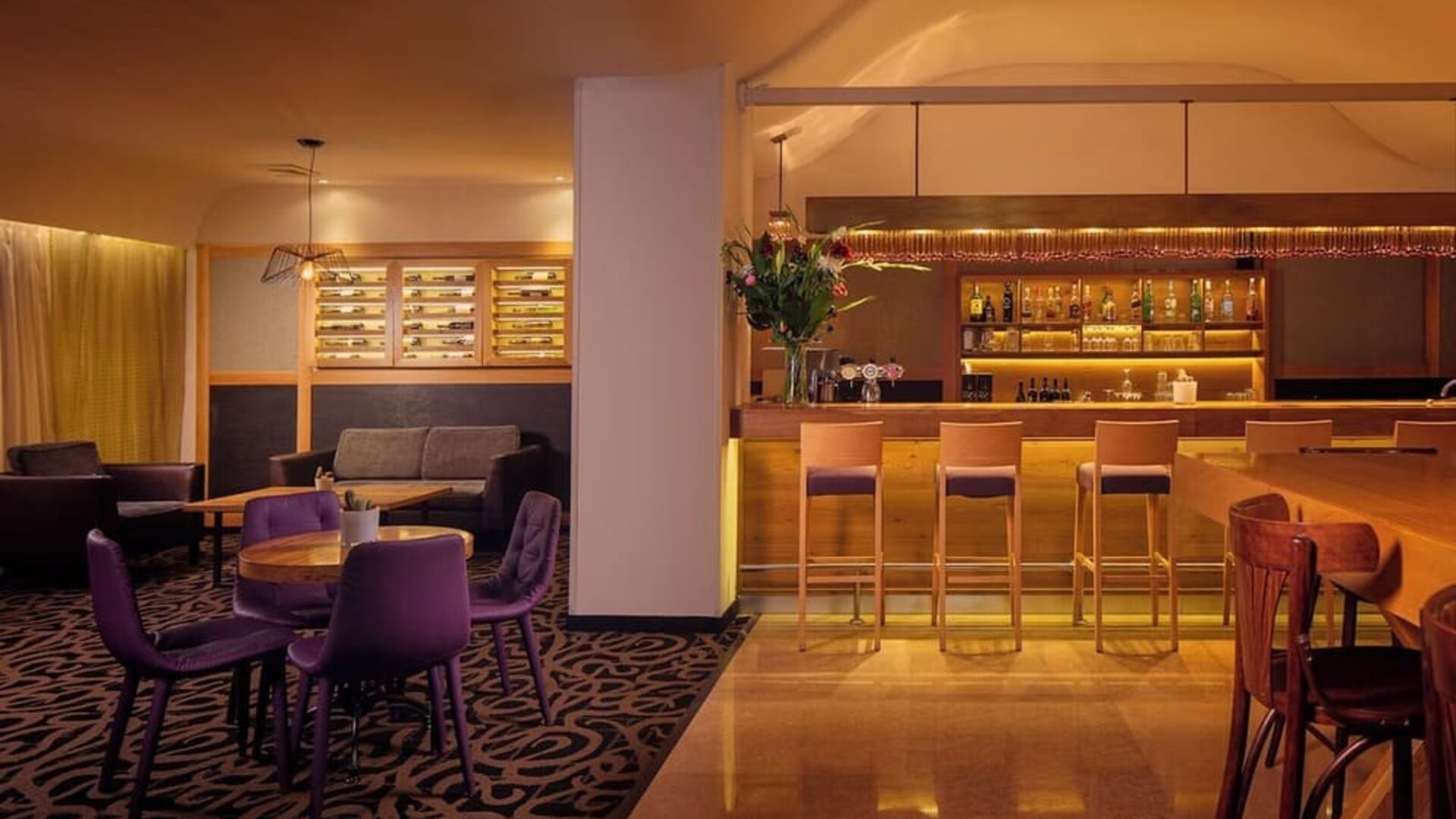 Hotel restaurant with booth seating, tables and chairs, decorative lighting, and a buffet counter in a spacious dining area at Prima Park Hotel.