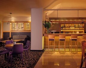 Hotel restaurant with booth seating, tables and chairs, decorative lighting, and a buffet counter in a spacious dining area at Prima Park Hotel.