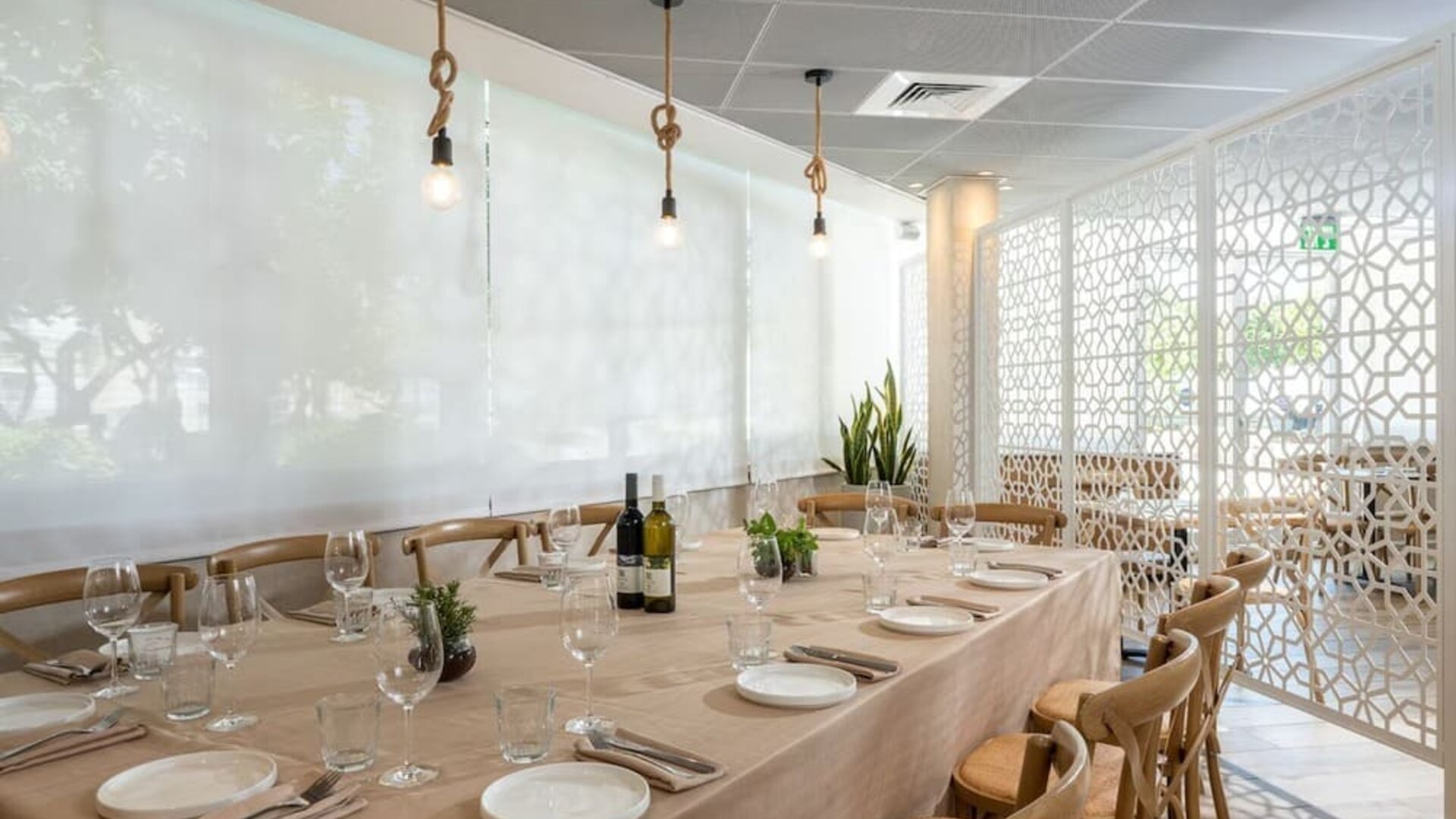 Private dining room with a long table, elegant table settings and wooden chairs at Prima Galil Tiberias.