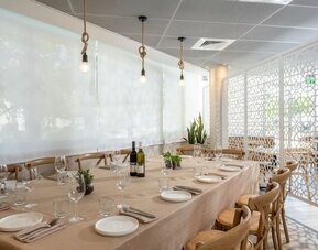 Private dining room with a long table, elegant table settings and wooden chairs at Prima Galil Tiberias.