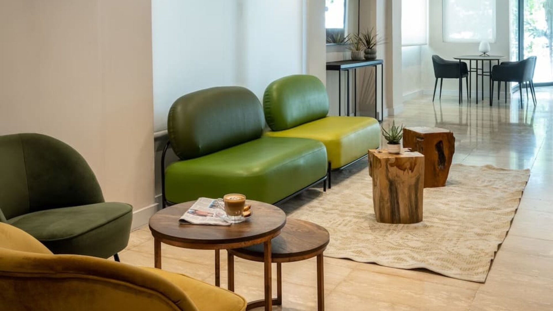 Lobby lounge with contemporary green seating, wooden tables and a bright minimalist interior at Prima Galil Tiberias.