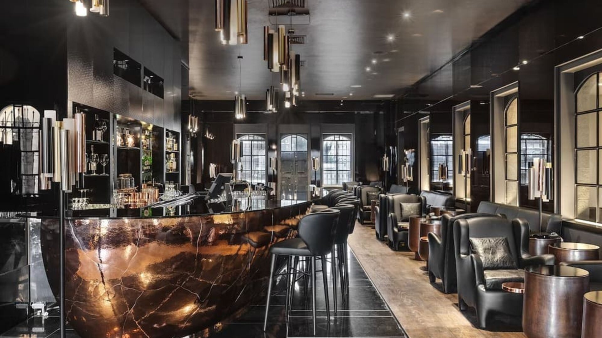 Hotel bar with dark marble counter, bar stools and leather lounge seating at Lady Stern Hotel.